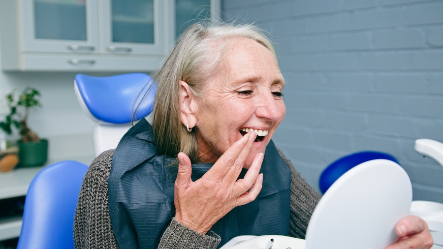 woman smiling at dentist after full mouth restoration in Amarillo